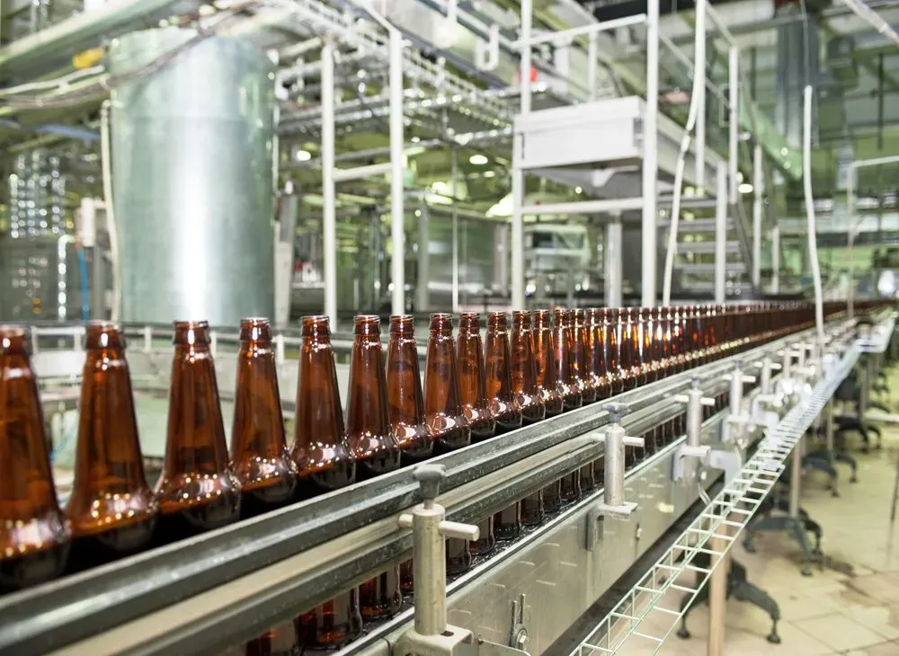 Brown beer bottles on a conveyor in a bottling hall