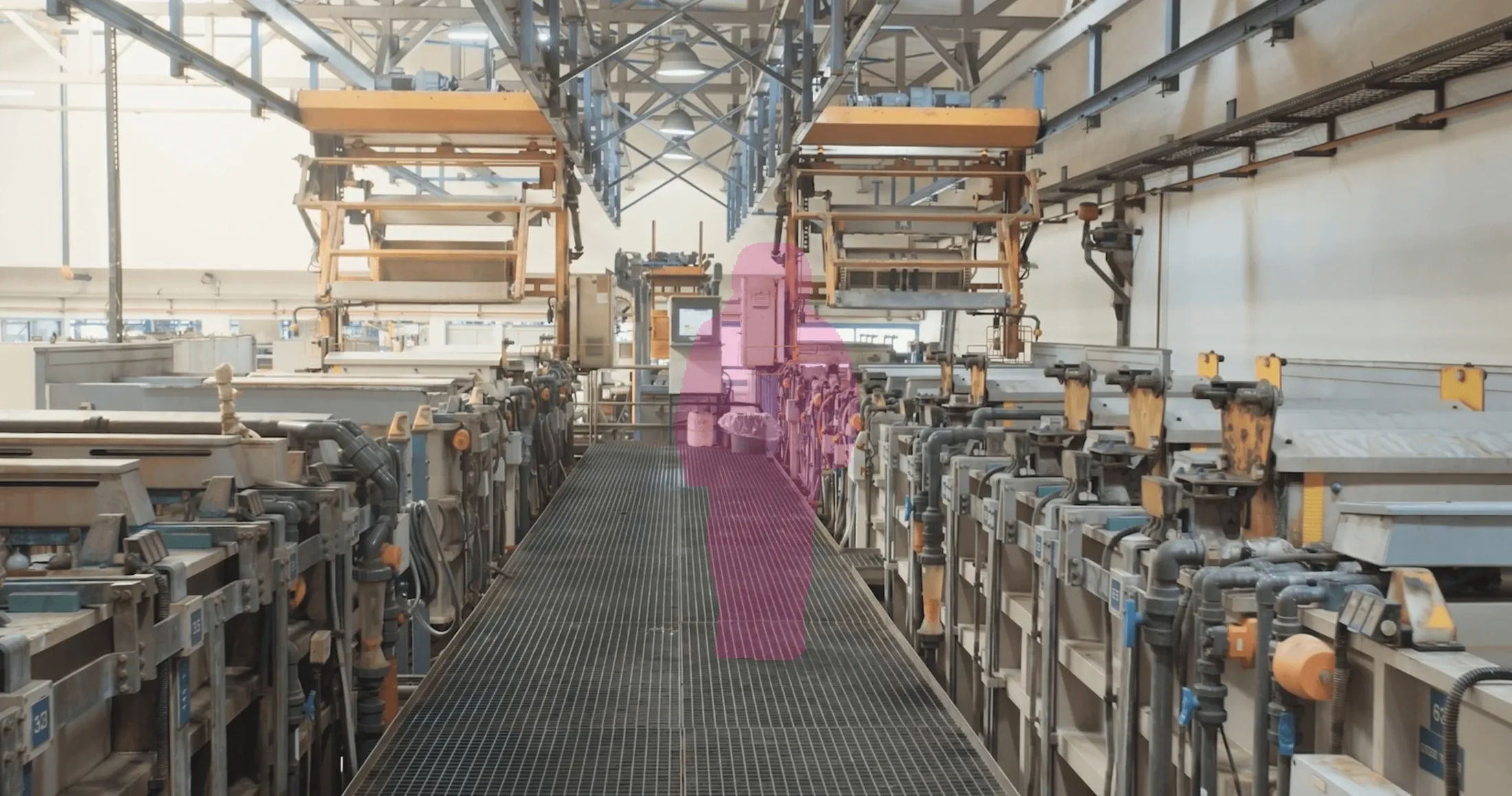 The same frame with the worker covered by a translucent anonymization mask